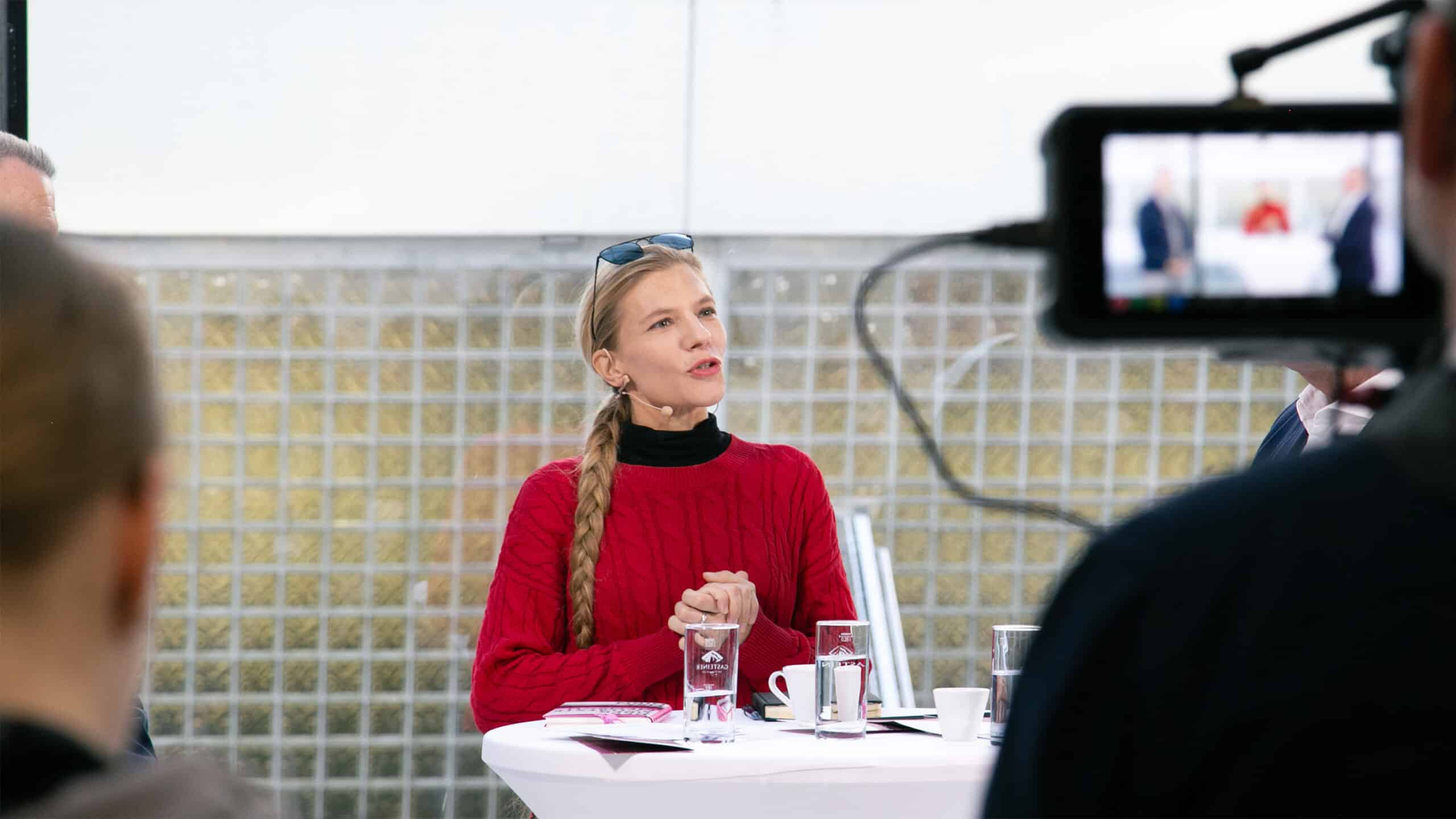 Speakerin mit langem Zopf spricht auf dem Denkfrühstück