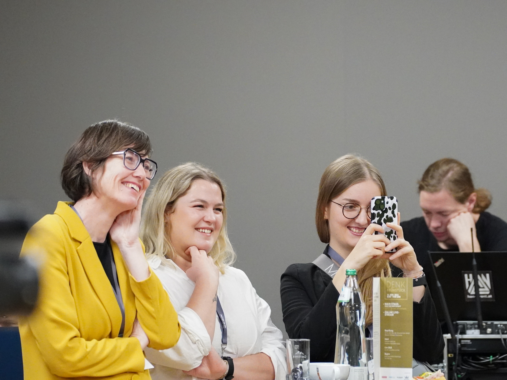 Drei Frauen lachen und fotografieren mit dem Handy beim Denkfrühstück