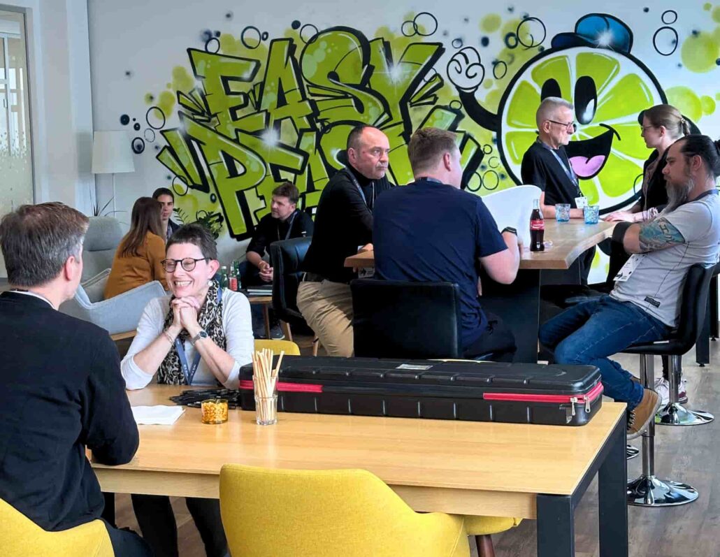Menschen im entspannten Gespräch, im Hintergrund ein Graffitti mit Zitronen-Smiley