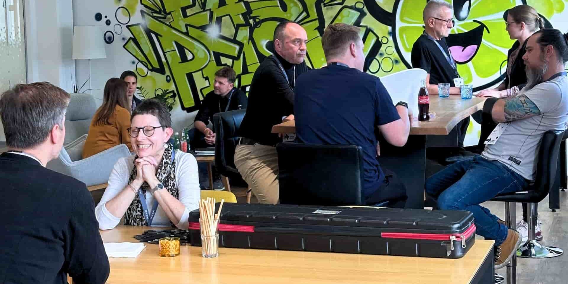 Menschen im entspannten Gespräch, im Hintergrund ein Graffitti "Easy Peasy" mit einem Zitronen-Smiley
