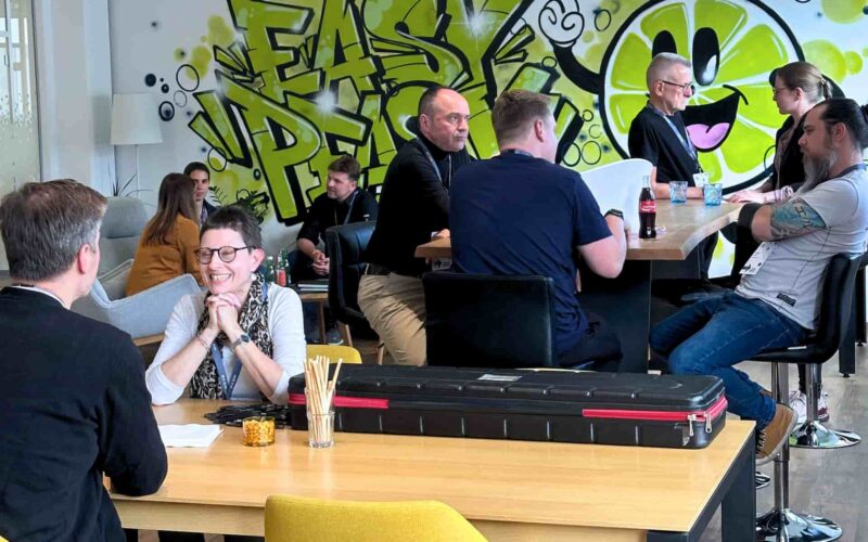 Menschen im entspannten Gespräch, im Hintergrund ein Graffitti "Easy Peasy" mit einem Zitronen-Smiley