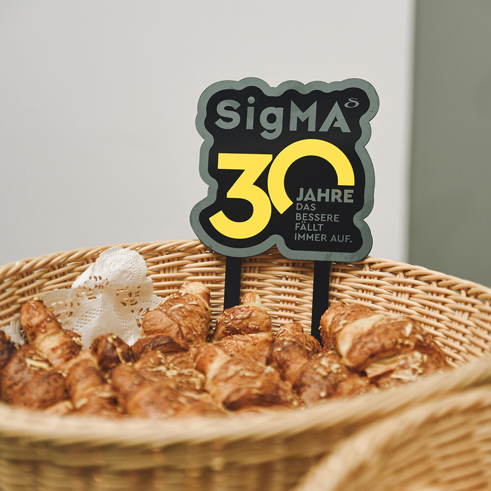 Korb mit Croissants und Schild: SigMA 30 Jahre