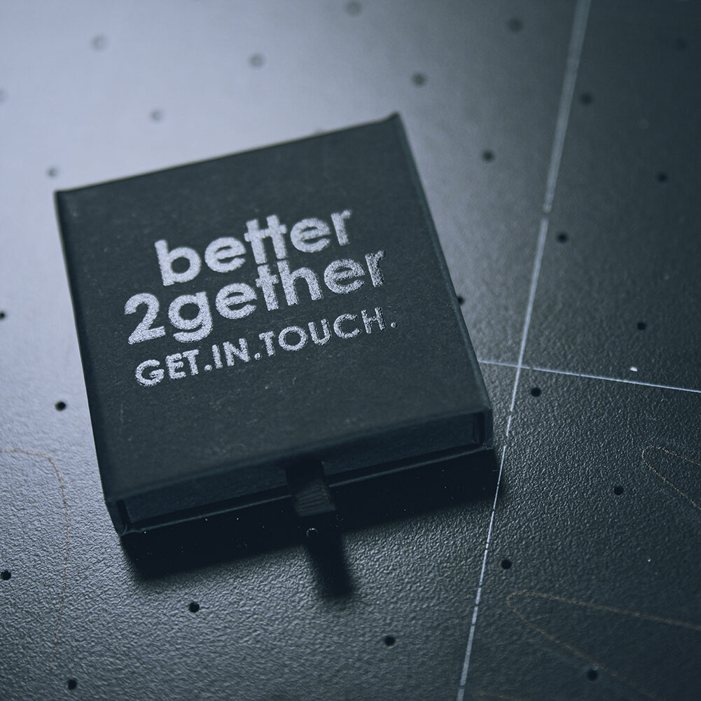 Schwarze Schachtel mit Aufdruck: better2gether GET.IN.TOUCH.