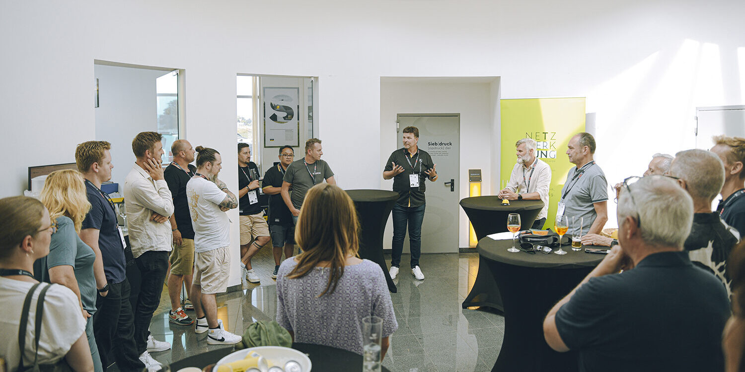Gruppe bei Sigma Werbetechnik Präsentation, ein Mann spricht zu den Zuhörenden