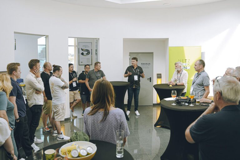 Gruppe bei Sigma Werbetechnik Präsentation, ein Mann spricht zu den Zuhörenden