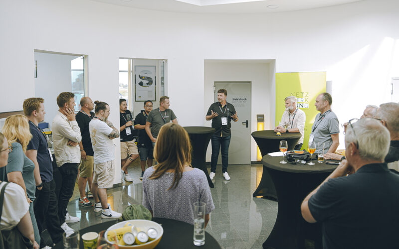 Gruppe bei Sigma Werbetechnik Präsentation, ein Mann spricht zu den Zuhörenden