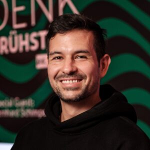 JeanClaude Grieco im Portrait vor Denkfrühstück-Aufsteller