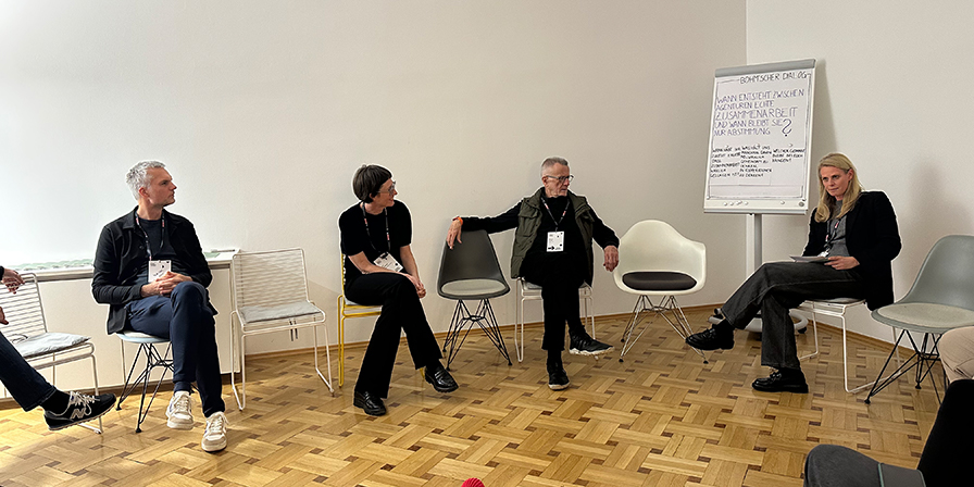 Vier Personen befinden sich in Agenturräumlichkeiten