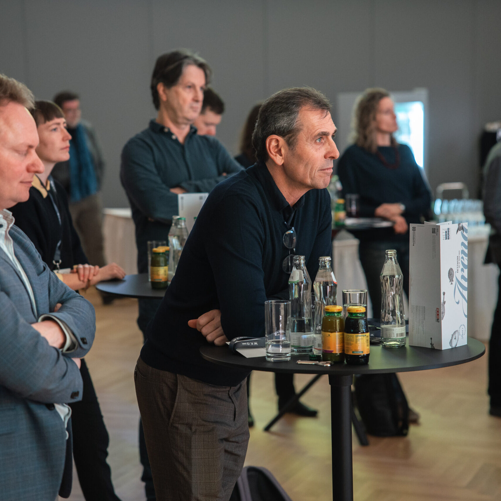 Zuhörer lehnt am Stehtisch