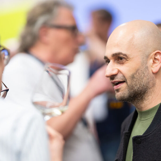 Ein Besucher der Netzwerk Arena im Gespräch mit einer Frau