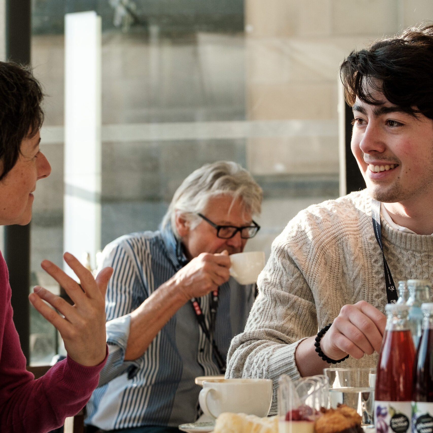 Zwei Denkfrühstück Teilnehmer reden und lachen gemeinsam, im Vordergrund stehen Getränke auf einem Tisch