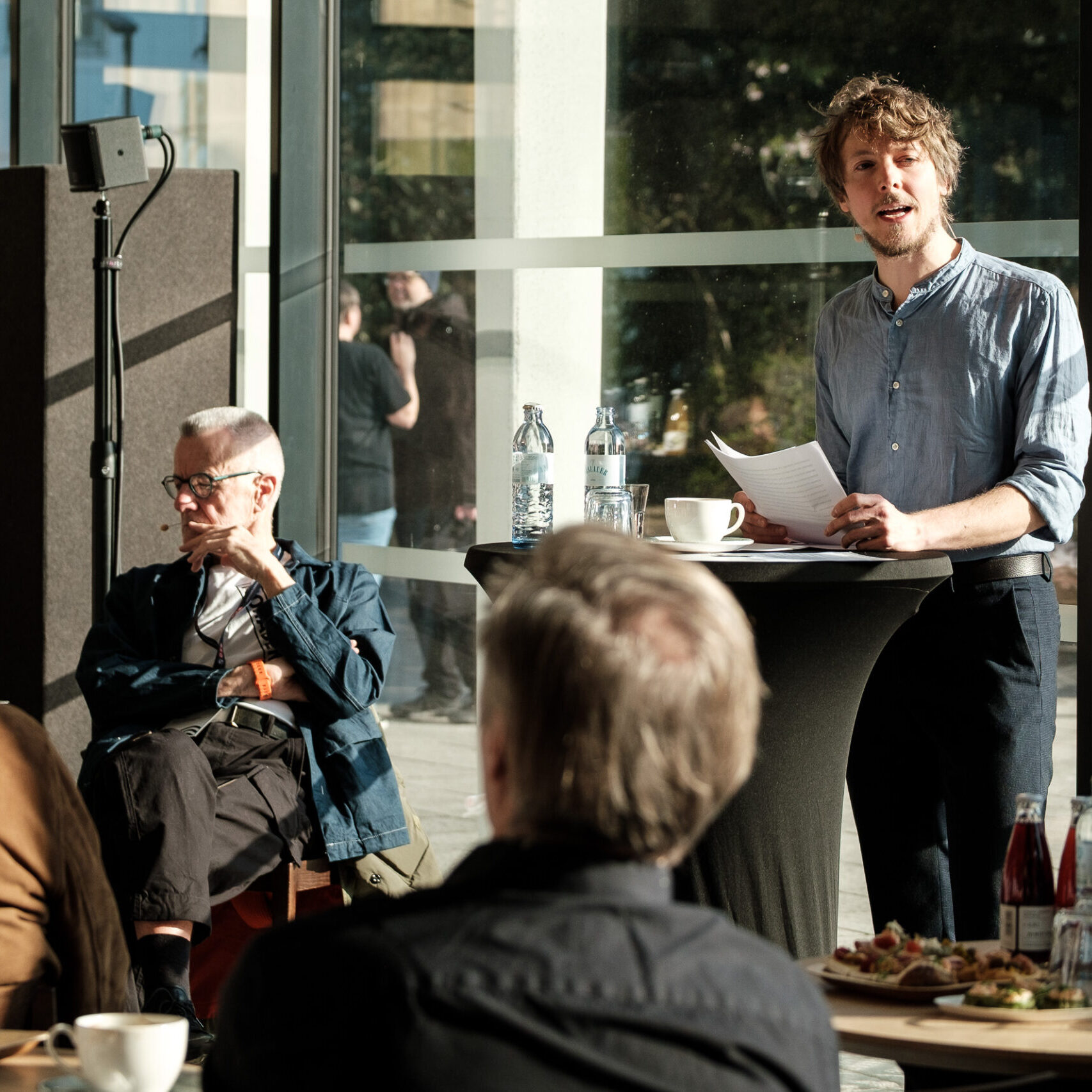 Der Speaker Matthias Leichtfried am Rednerpult; rundherum sind Denkfrühstück-Teilnehmer:innen zu sehen
