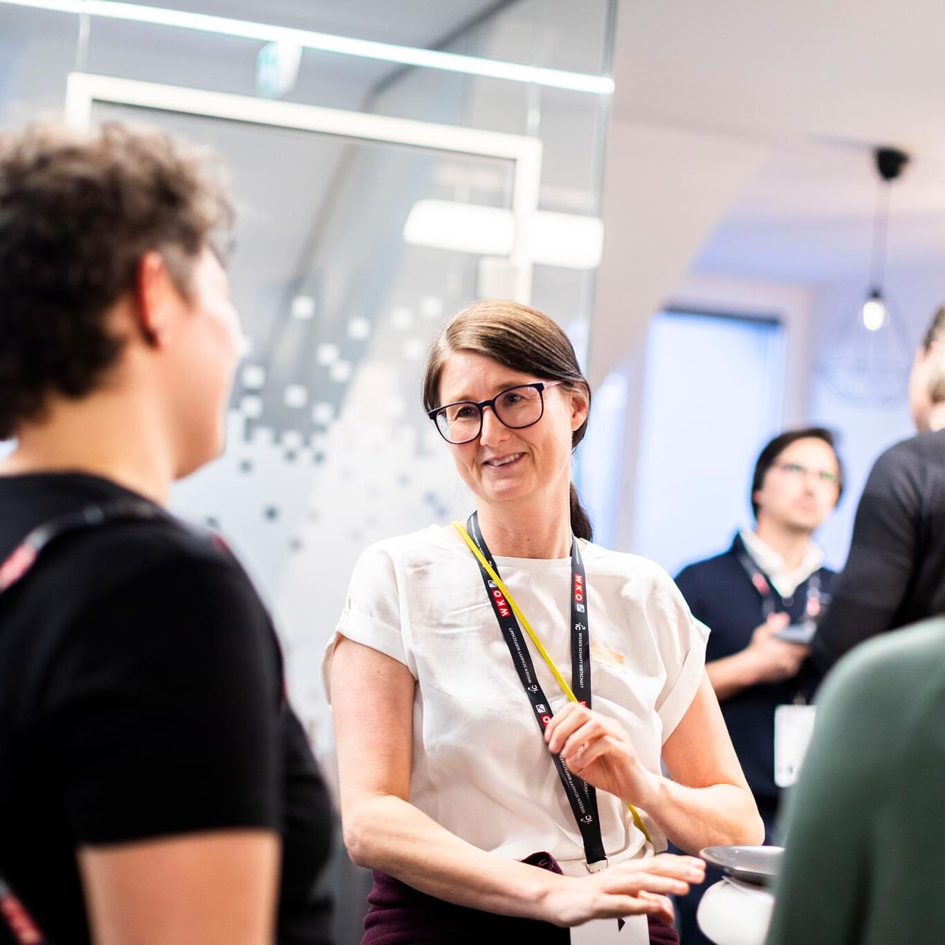 Susanne Trhal im Porträt beim better2gether-Event, weitere Gäste sind zu sehen