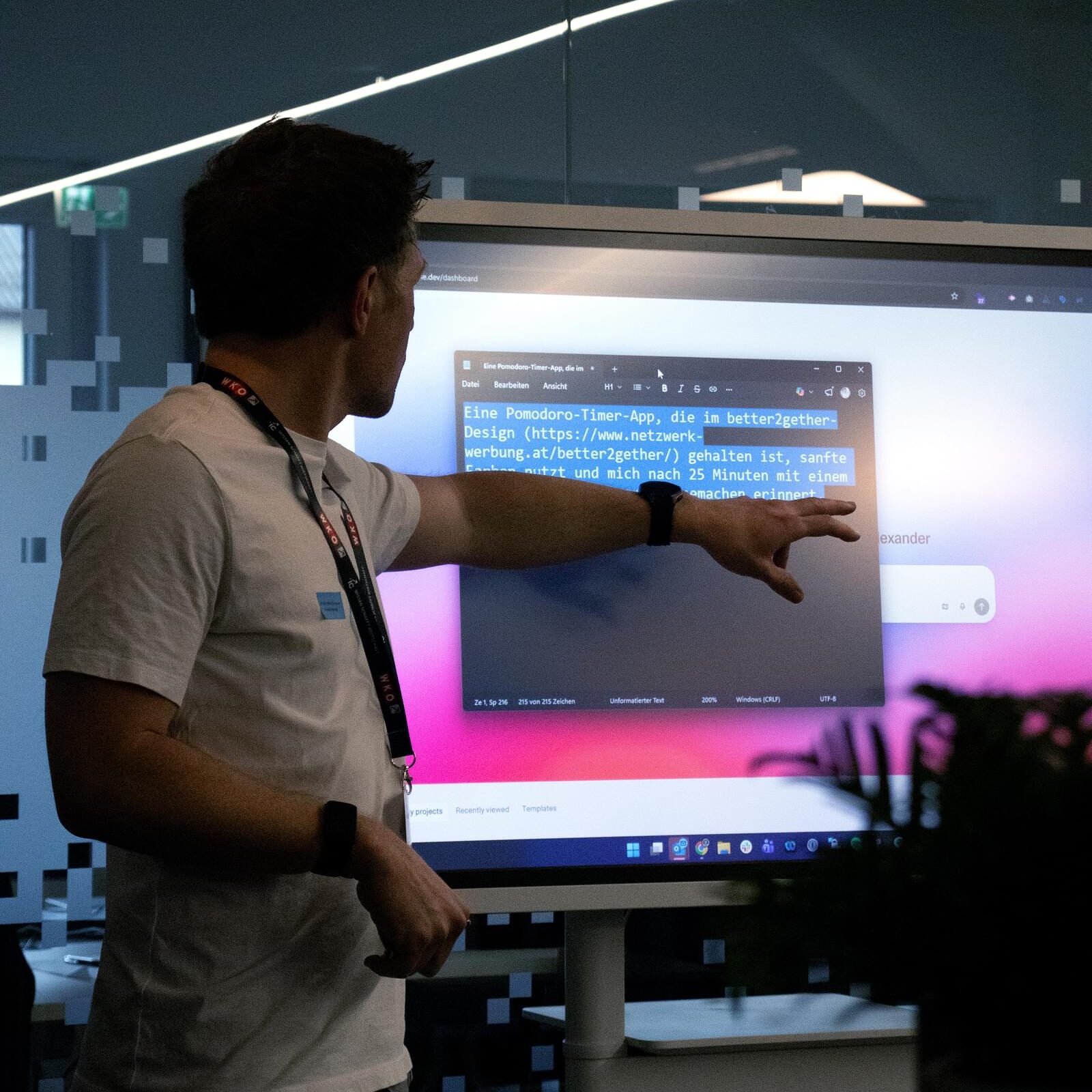 Ein Mann erklärt einen Code auf einem Bildschirm und zeigt darauf
