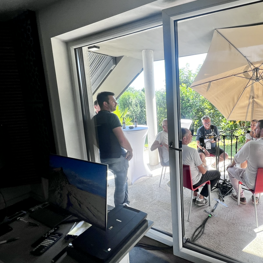 Gesprächsrunde mit Mikrofonen auf einer überdachten Terrasse