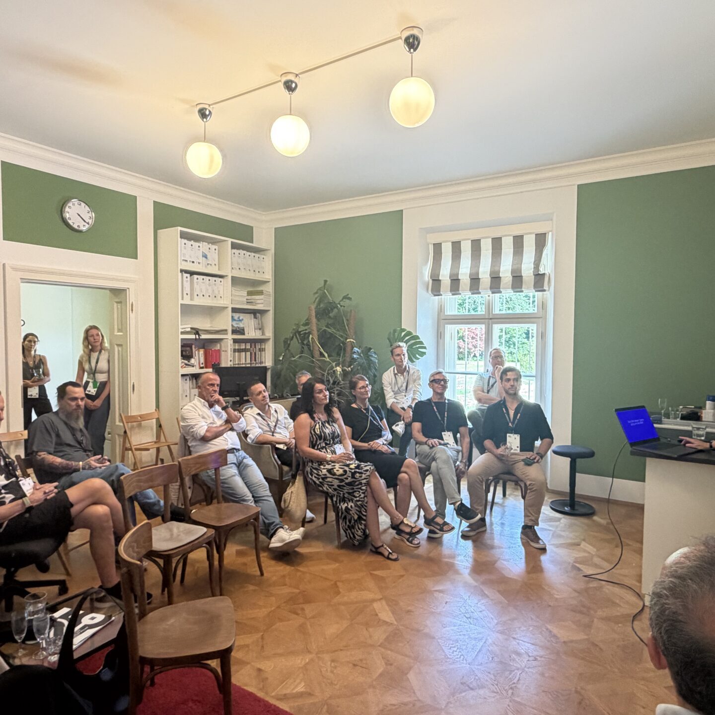 Teilnehmende sitzen während eines Workshops aufmerksam in einem Besprechungsraum.