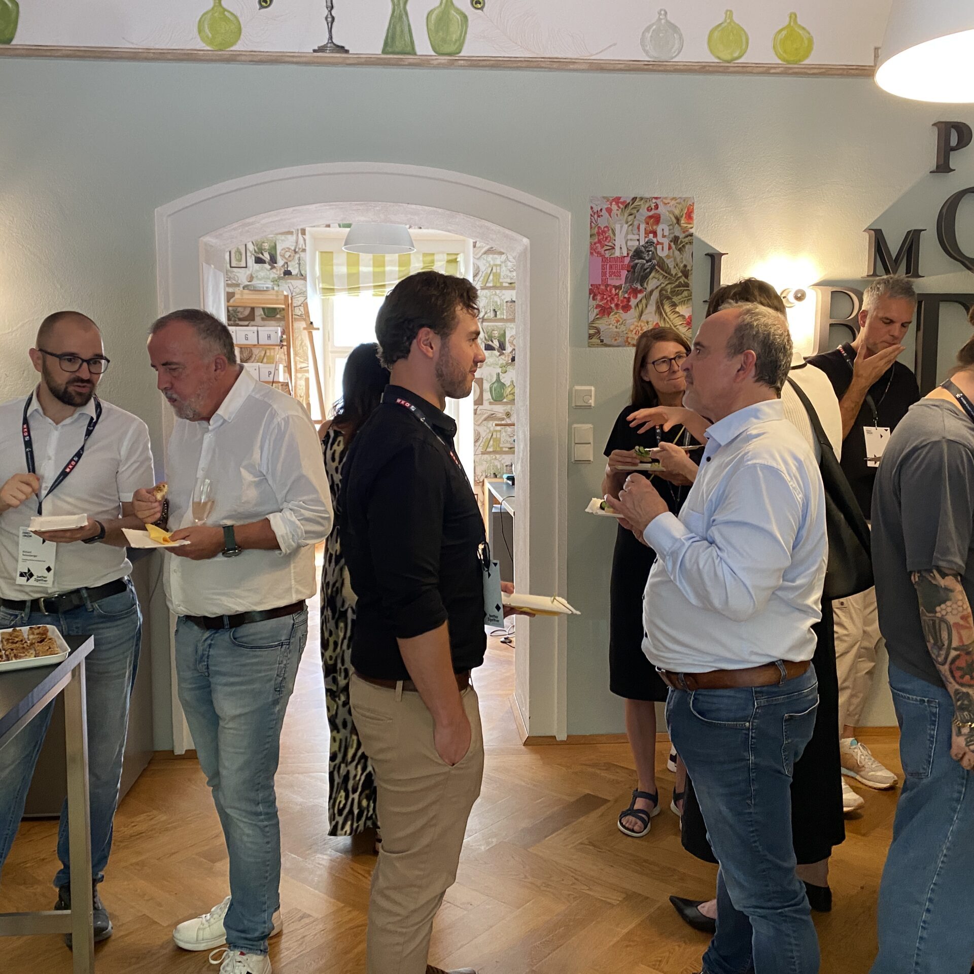 Teilnehmende unterhalten sich bei einer Workshop-Pause mit Getränken und Snacks