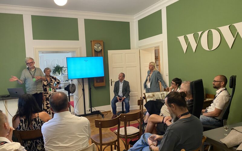 Workshop mit Vortragendem und Teilnehmenden in einem grünen Besprechungsraum.