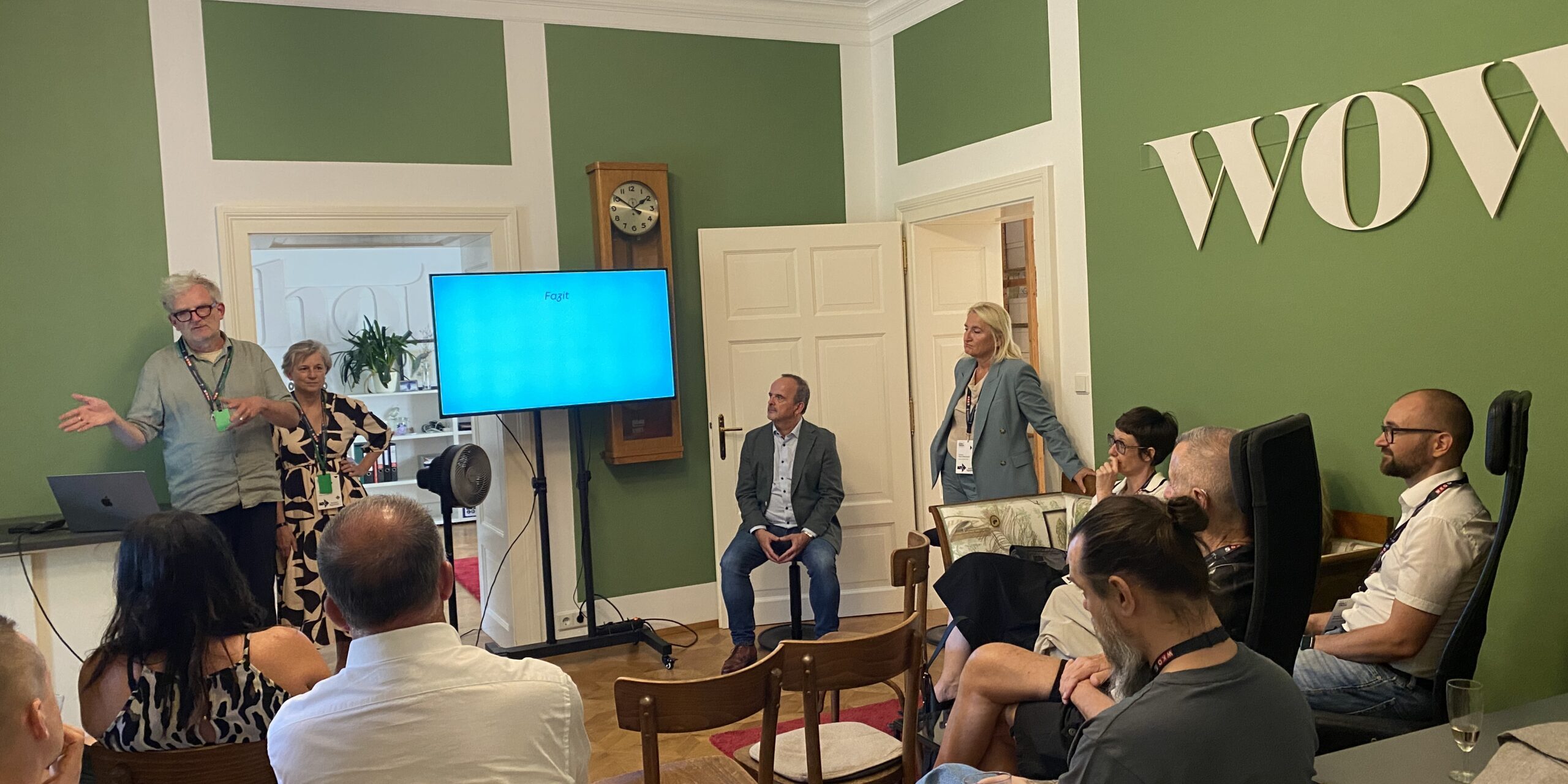 Workshop mit Vortragendem und Teilnehmenden in einem grünen Besprechungsraum.