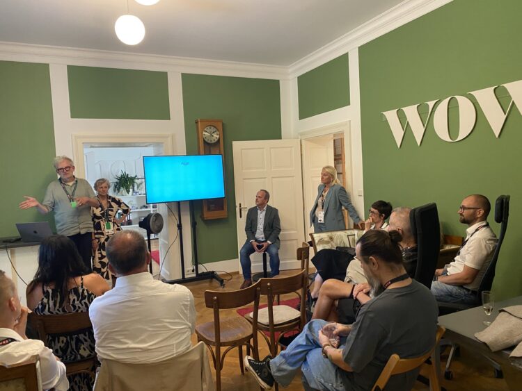 Workshop mit Vortragendem und Teilnehmenden in einem grünen Besprechungsraum.
