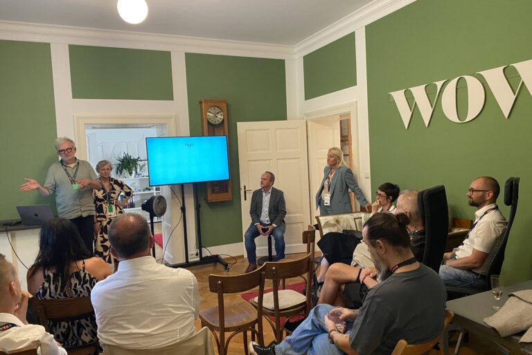 Workshop mit Vortragendem und Teilnehmenden in einem grünen Besprechungsraum.